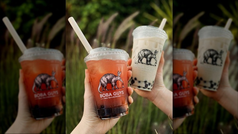 hands holding Boba Guys drinks