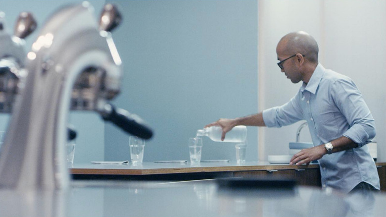 Server pouring water at countertop