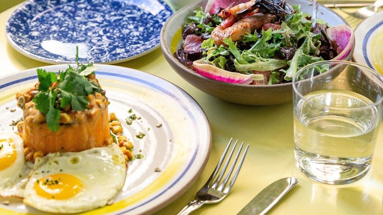 Eggs, salad, plates on table