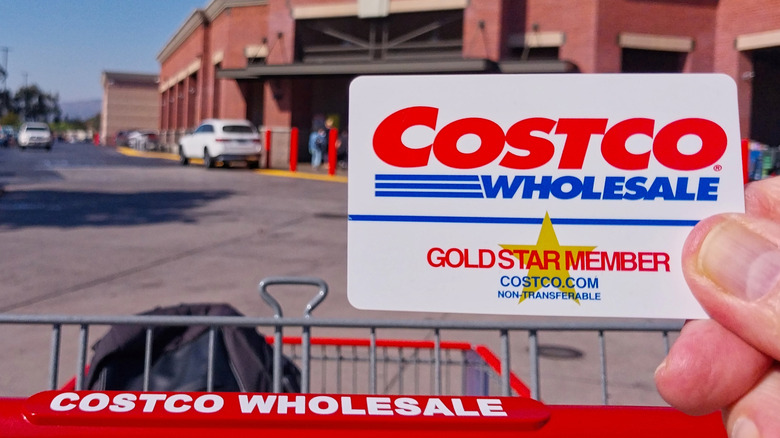 person holding Costco card outside of store