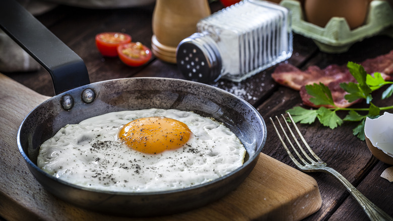 Egg frying in iron skillet