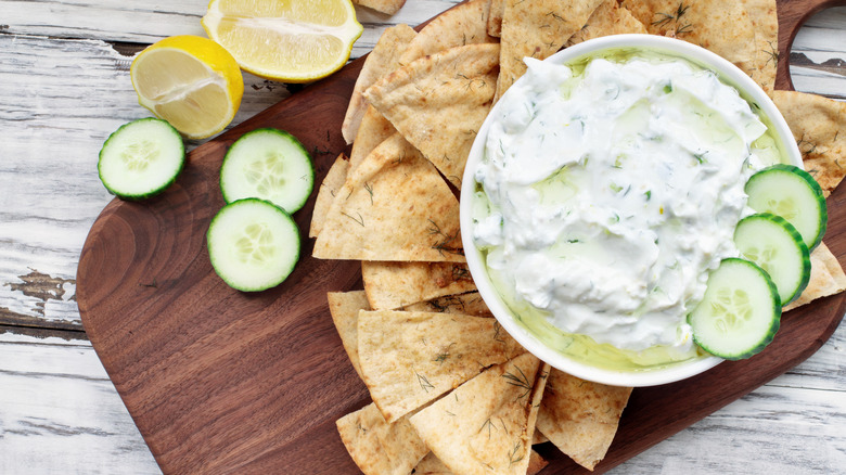 A platter with tzatziki with cucumbers and pita bread