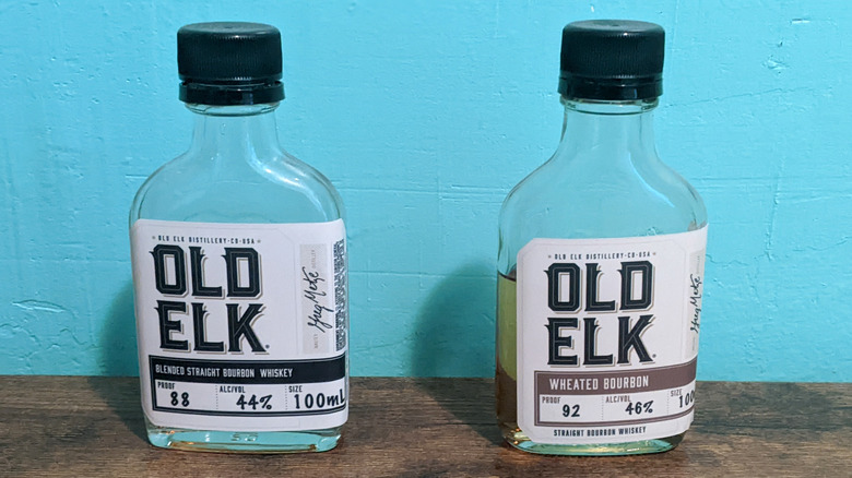 Old Elk bourbon sample bottles on a table in front of a blue wall