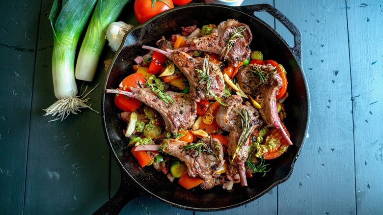 lamb chops, vegetables in skillet