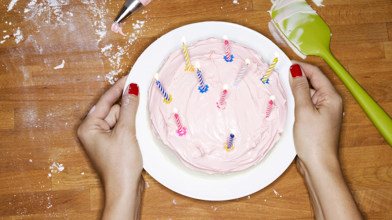 Home baker holding a hand-frosted cake