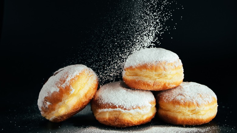 dusting donuts with confectioners' sugar