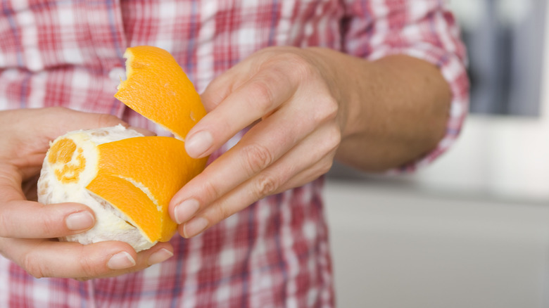 Person peeling an orange.