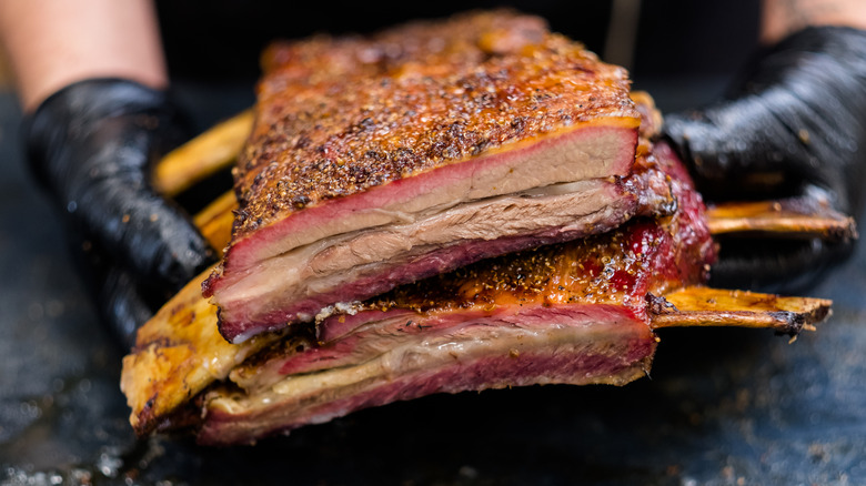 Person holding up short plate ribs