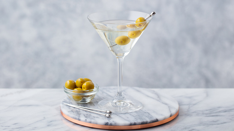 dirty martini in a glass garnished with olives