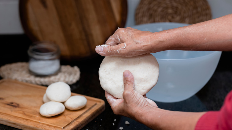 hands making arepas