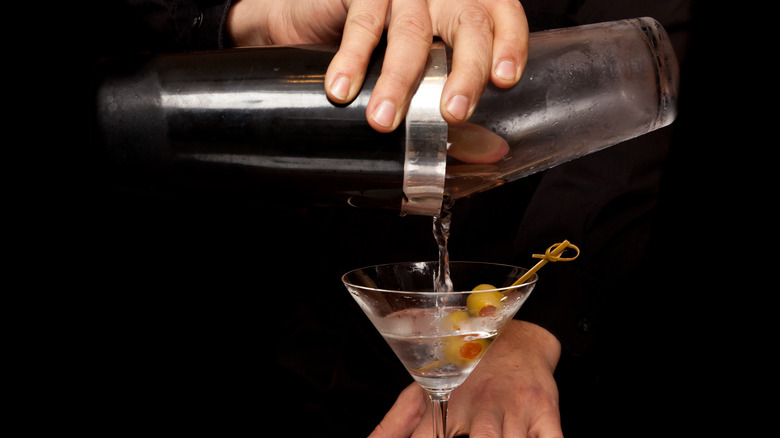 bartender using boston shaker to pour martini