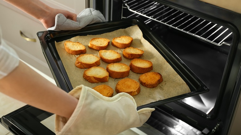 Putting homemade breadcrumbs into the oven