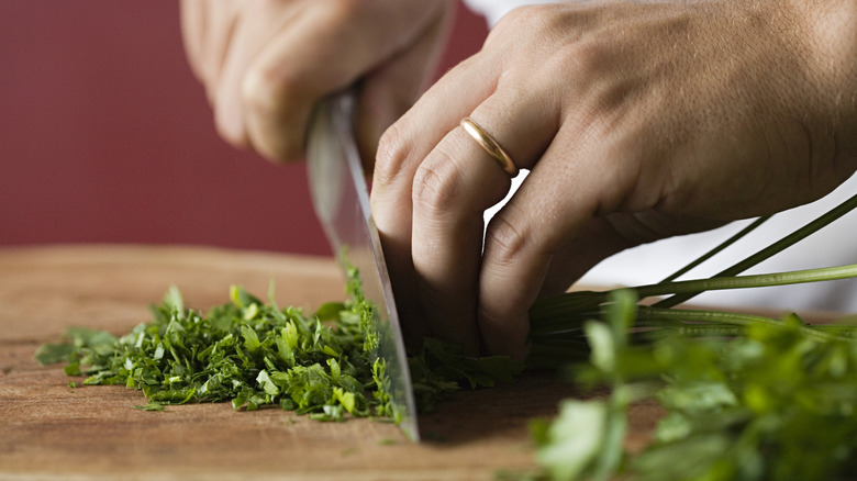 a close view of a person chopping herbs