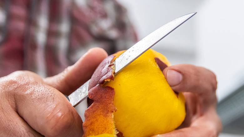 A chef peeling a peach