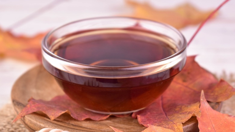 A bowl of Very Dark maple syrup with leaves