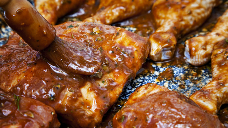 brushing barbecue sauce on ribs