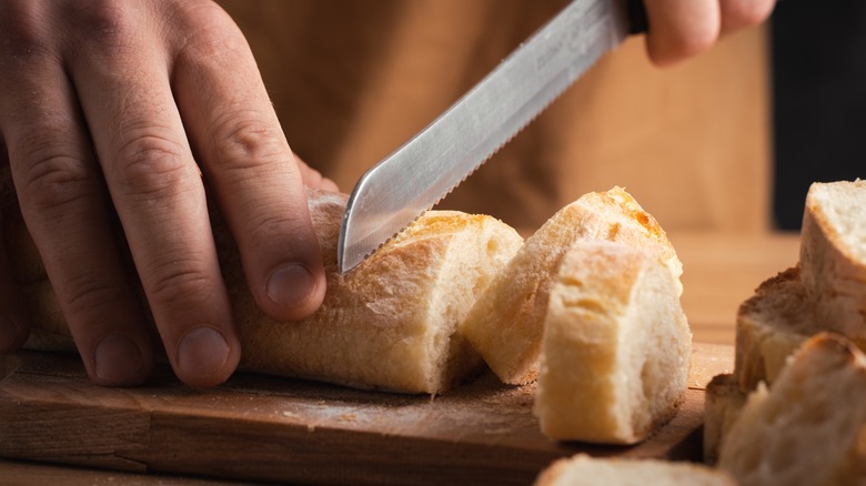 Serrated knife cutting a baguette