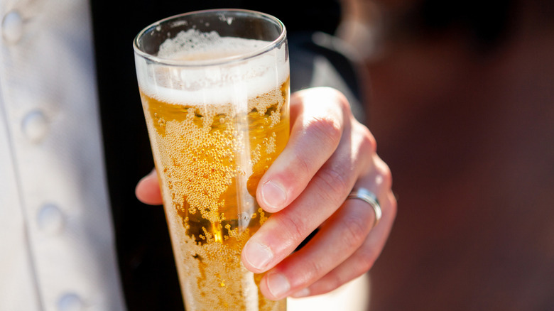 hand holding a glass of pilsner beer