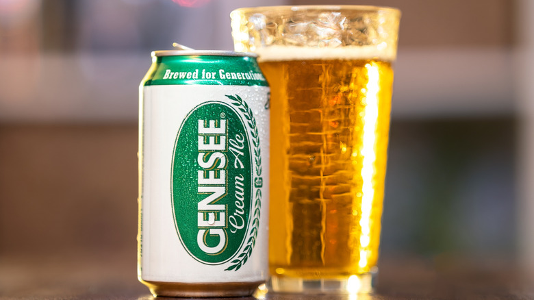 A can of Genesee cream ale next to a tall glass of the beer