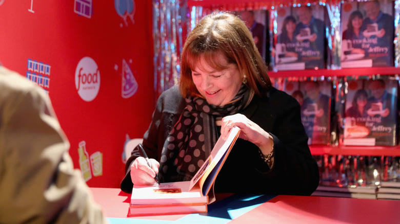 Ina Garten cheerfully signing cookbooks