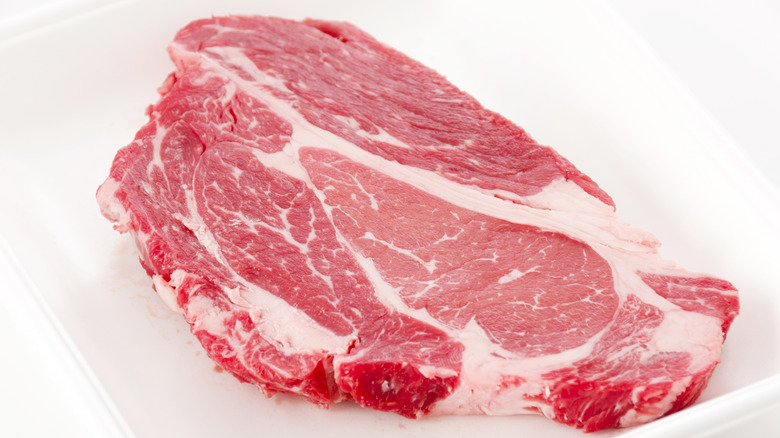 Raw beef chuck steak on white