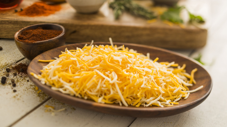 shredded cheese in wooden dish