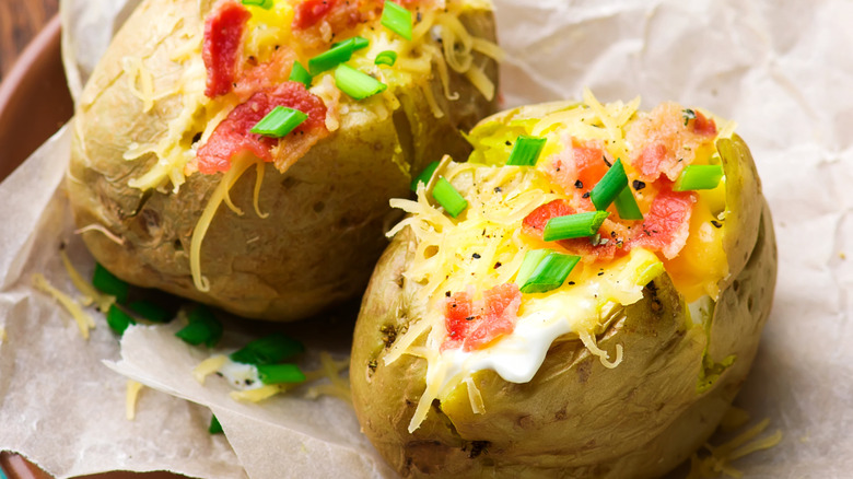 Baked potatoes stuffed with shredded cheese, bacon, and green onions