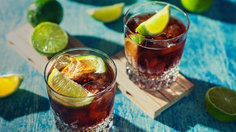 Two glasses of bourbon and Coke with limes