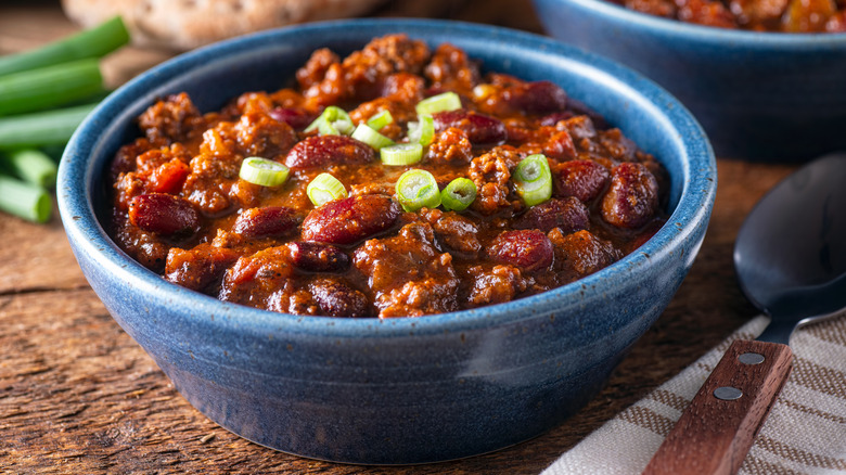 Bowl of chili green onions blue