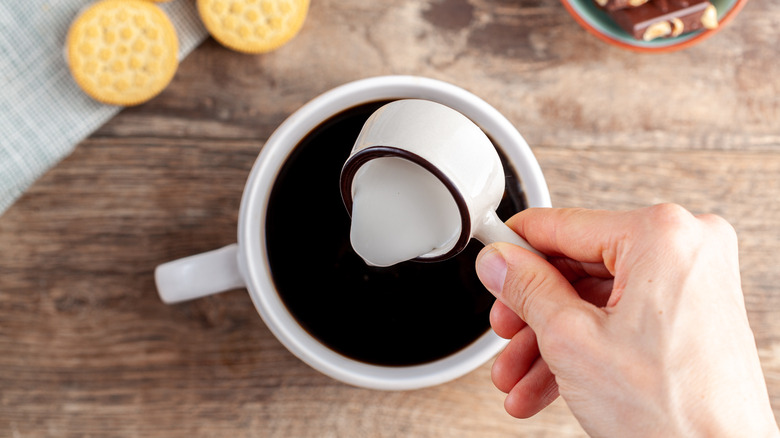 Pouring half-and-half creamer into coffee