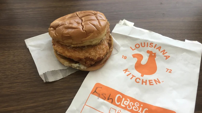 Popeye's blurred sandwich on a table next to his wrapper