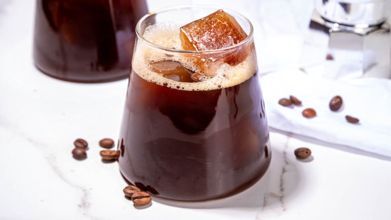 Cold brew espresso cocktail with frozen espresso ice cubes, strong black coffee, liqueur, and Amaro