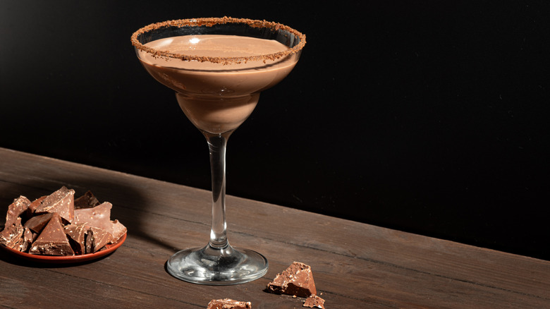 Brandy Alexander cocktail with nutmeg rim on wooden table