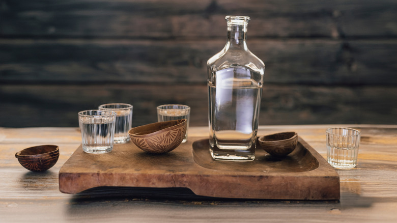 Bottle of mezcal with several glasses