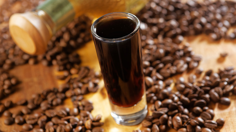 Tequila with coffee liqueur served in shot glass and surrounded by coffee beans