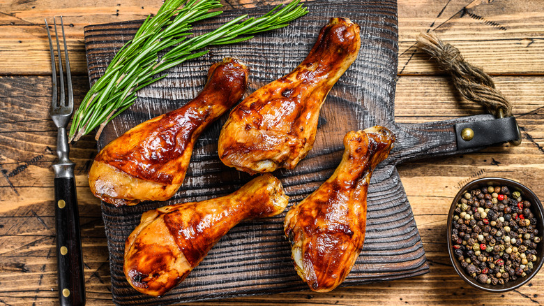 Barbecued drumsticks on cutting board