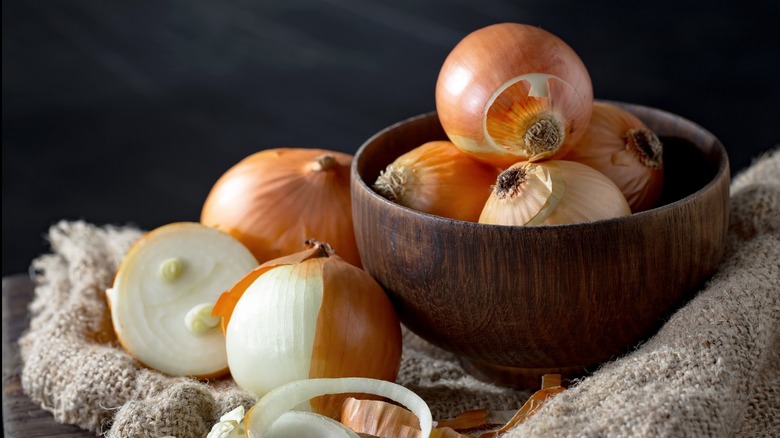 yellow onions in a wood serving bowl