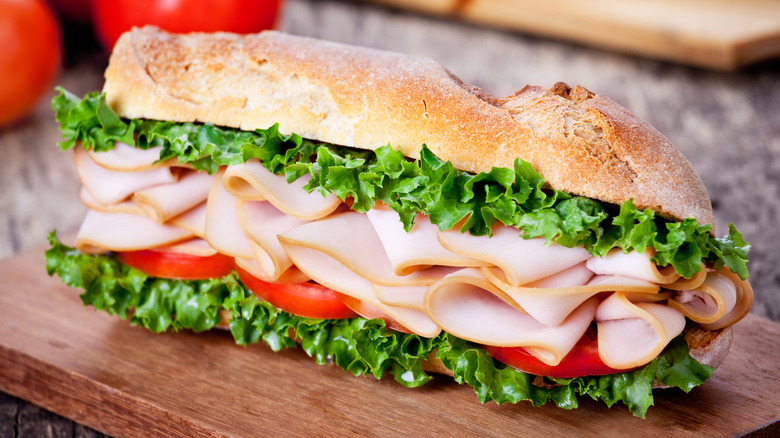 turkey sandwich in crusty bread with lettuce and tomato