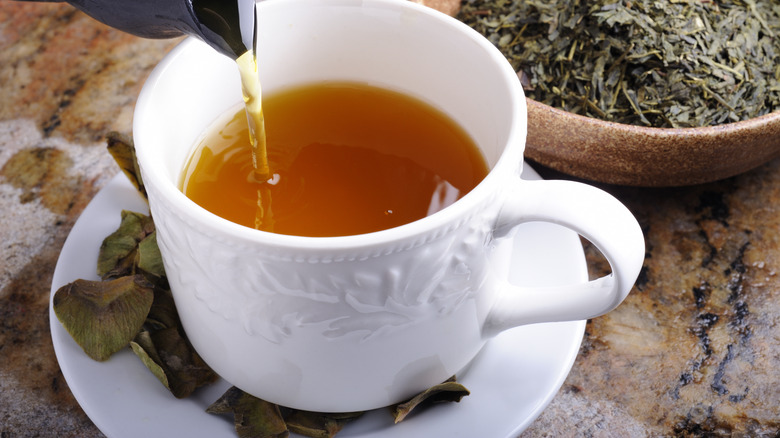 white tea cup with tea leaves