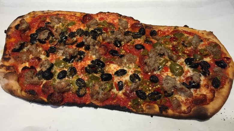 Long pizza with many toppings