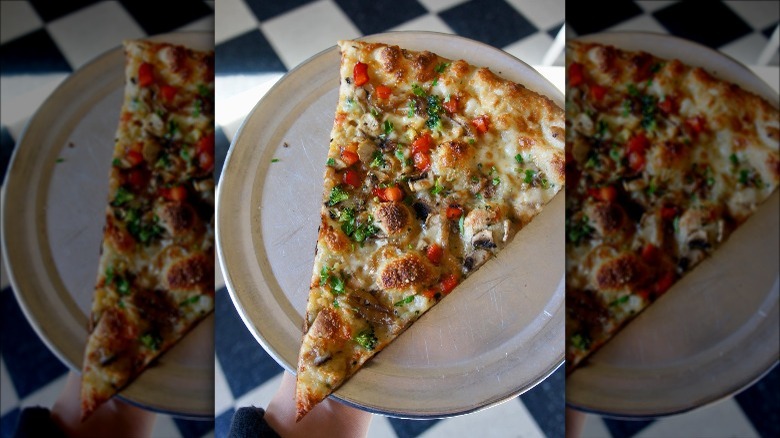 A slice of pizza on a metal tray