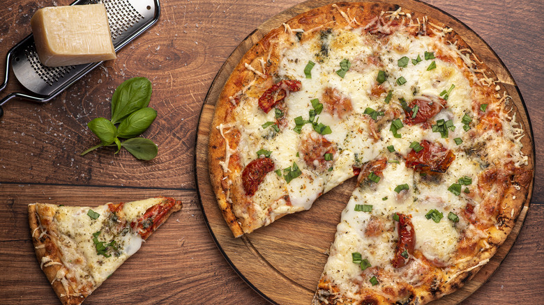 Pizza on a table with shredded cheese