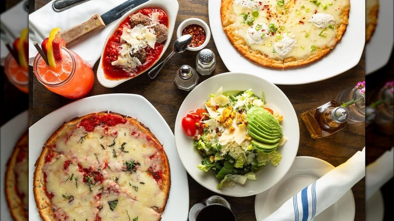 Table filled with pizza and other food at Wild