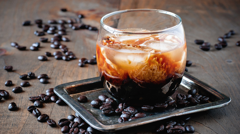 Bourbon-spiked cold brew surrounded by roasted coffee beans