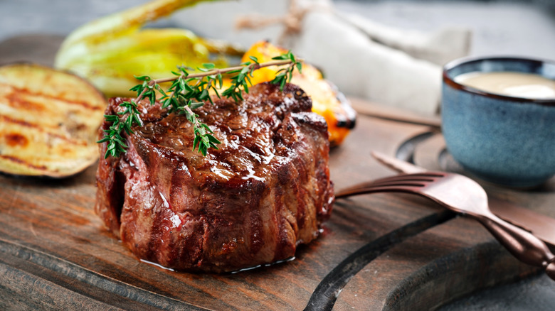 Grilled beef tenderloin sits on a cutting board