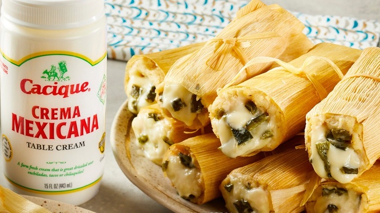 A container of Crema Mexicana next to tamales