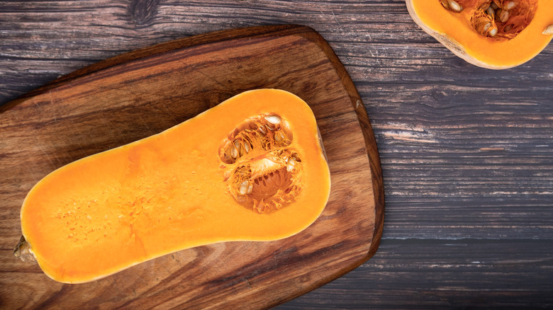 Halved butternut squash on wood cutting board