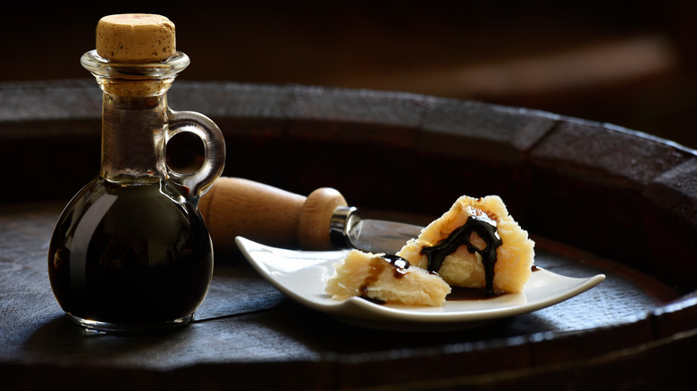 Jar balsamic vinegar piece of bread drizzled black