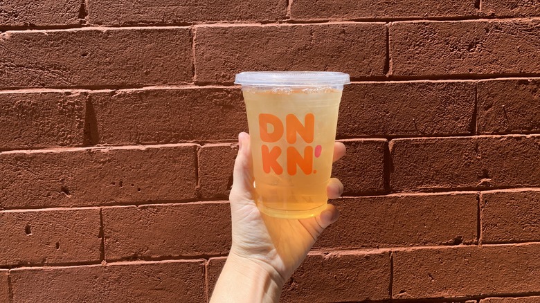 Dunkin iced green tea red brick wall