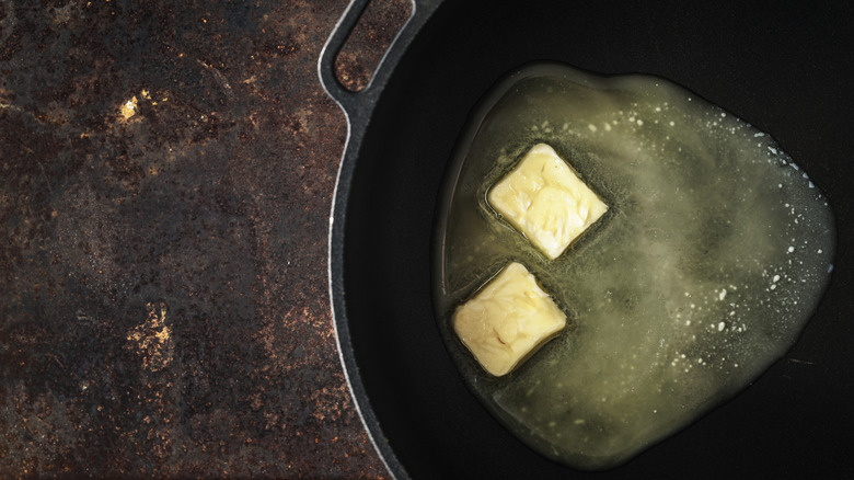 Butter melting in cast iron pan black